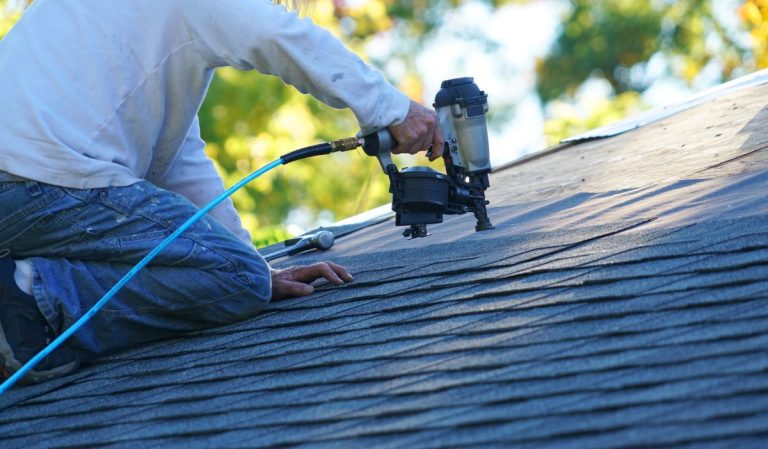 roofer repairing asphalt roof with nail gun, Lakeville, MN